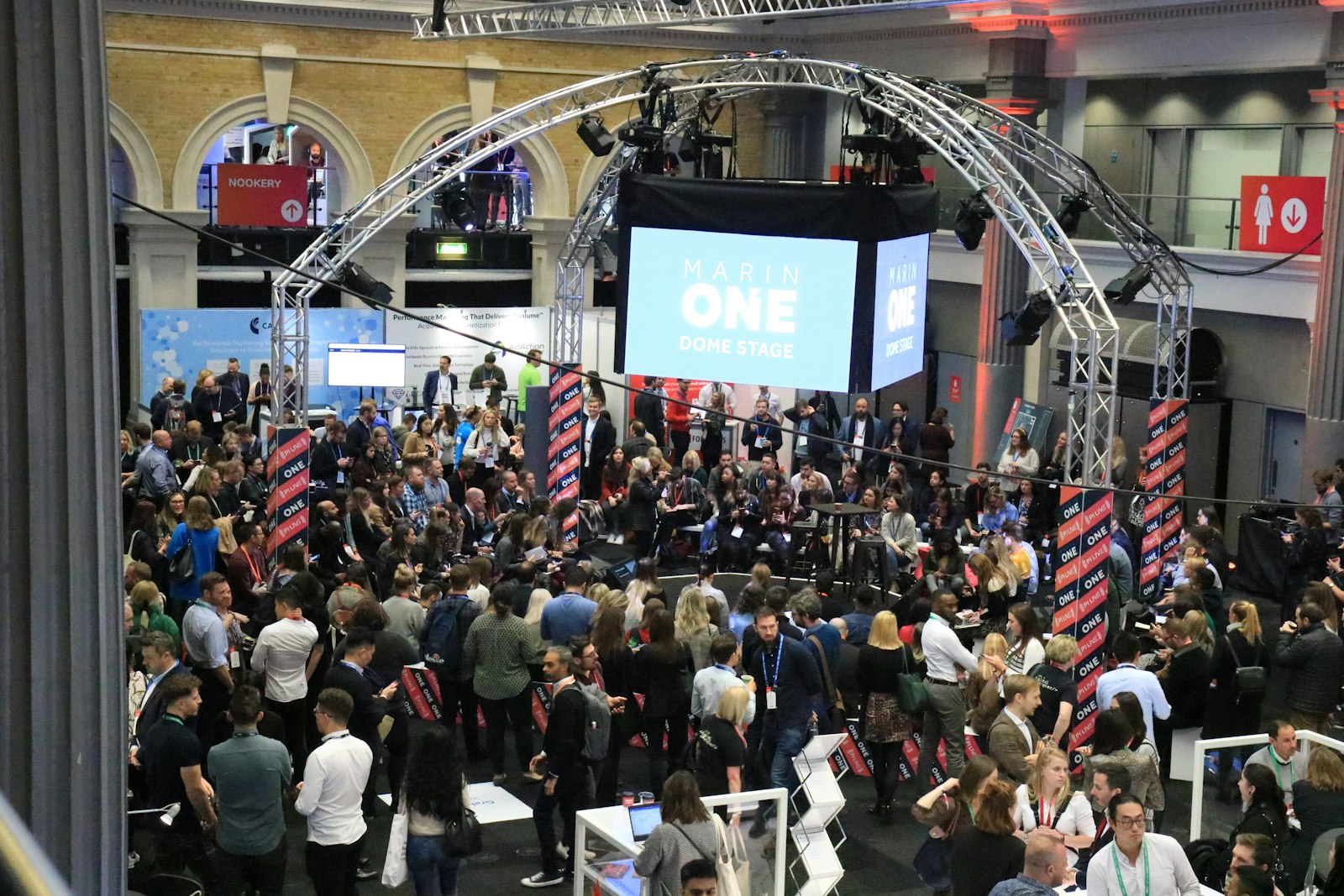 Crowd gathered at an indoor event with a large screen.