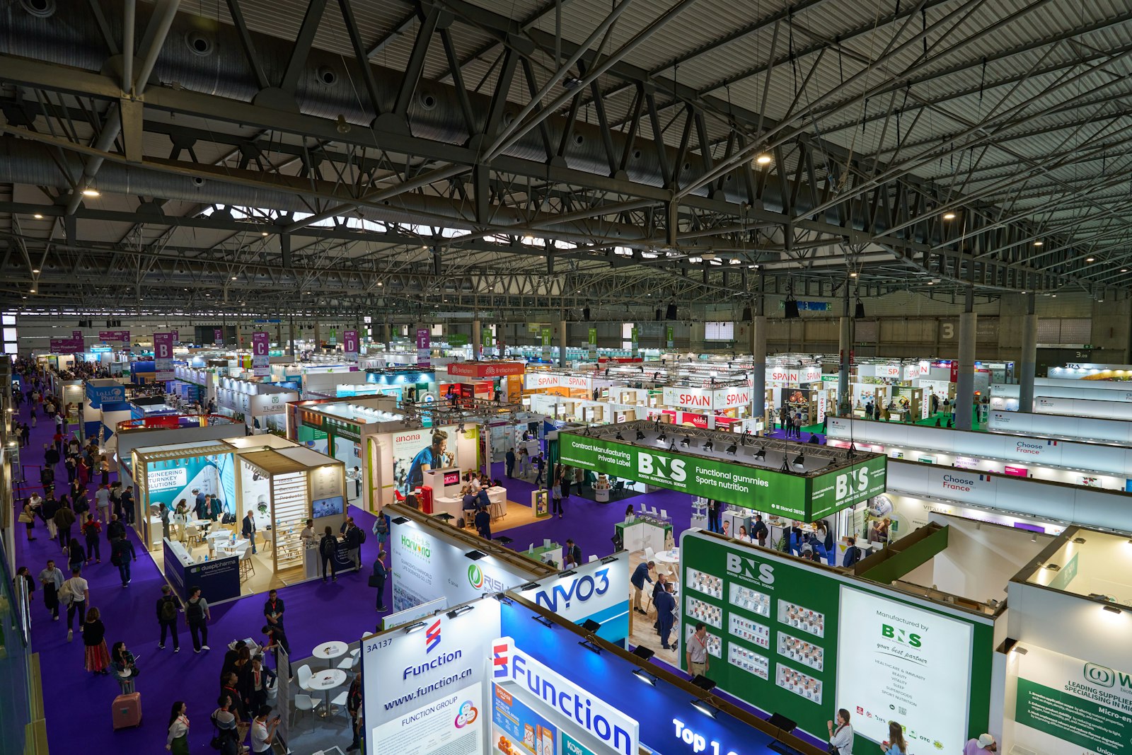 An indoor exhibition hall is full of vendors.
