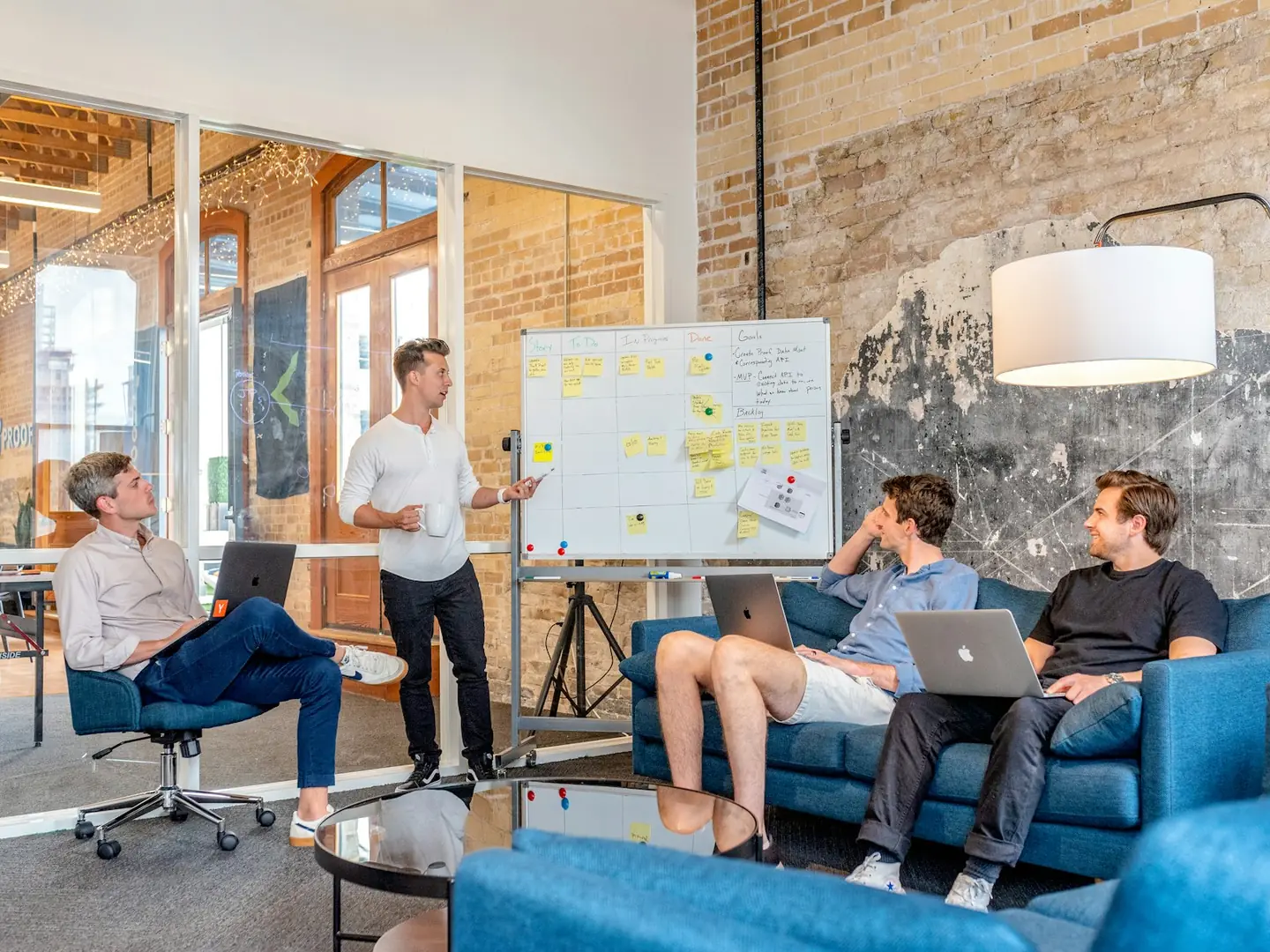 Team members using laptops beside a whiteboard