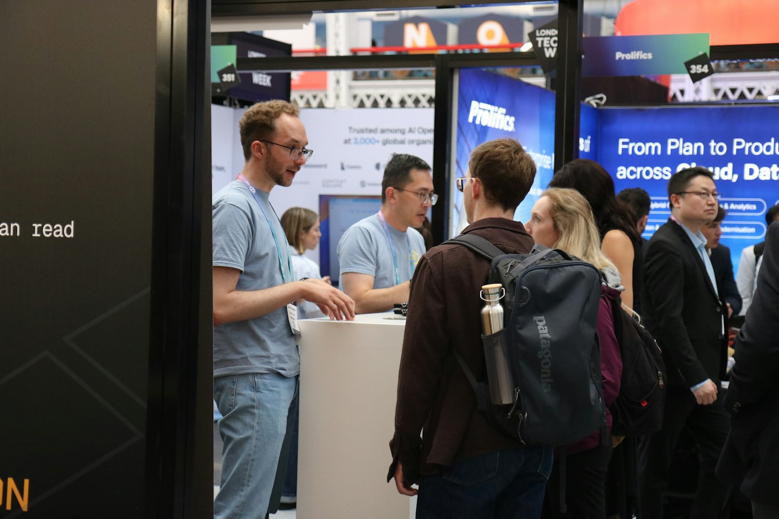 People interacting at a busy trade show booth