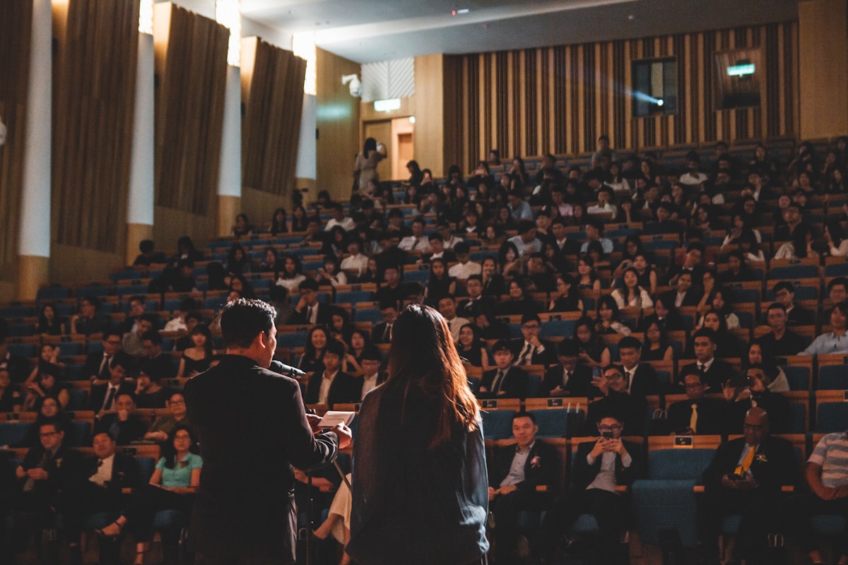 Speakers addressing a packed conference hall
